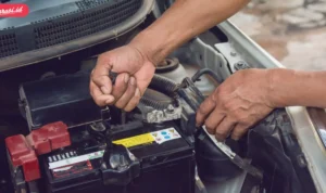 Cara ganti aki mobil yang diletakkan di bawah karpet bagasi: Melepas aki lama